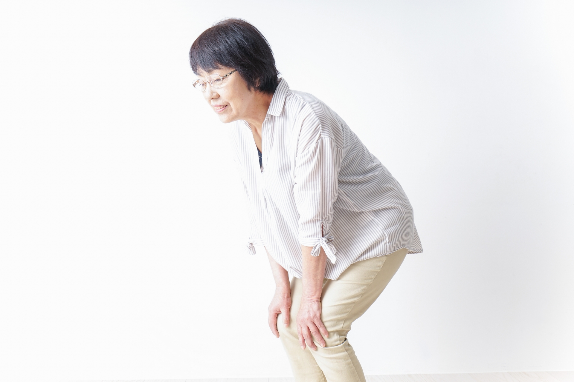 膝の痛みに悩みながら立ち上がりを気にしている女性のイメージ