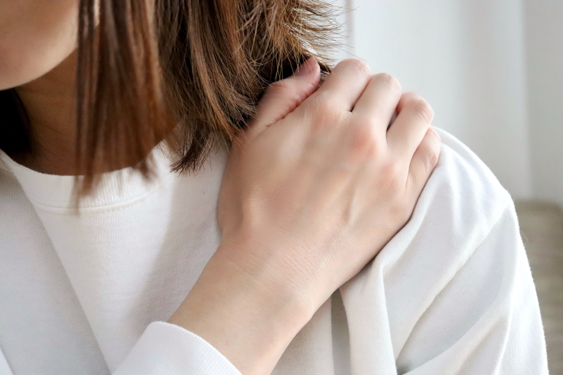 肩に強い刺激を与えて揉んでいるが改善しない様子のイメージ