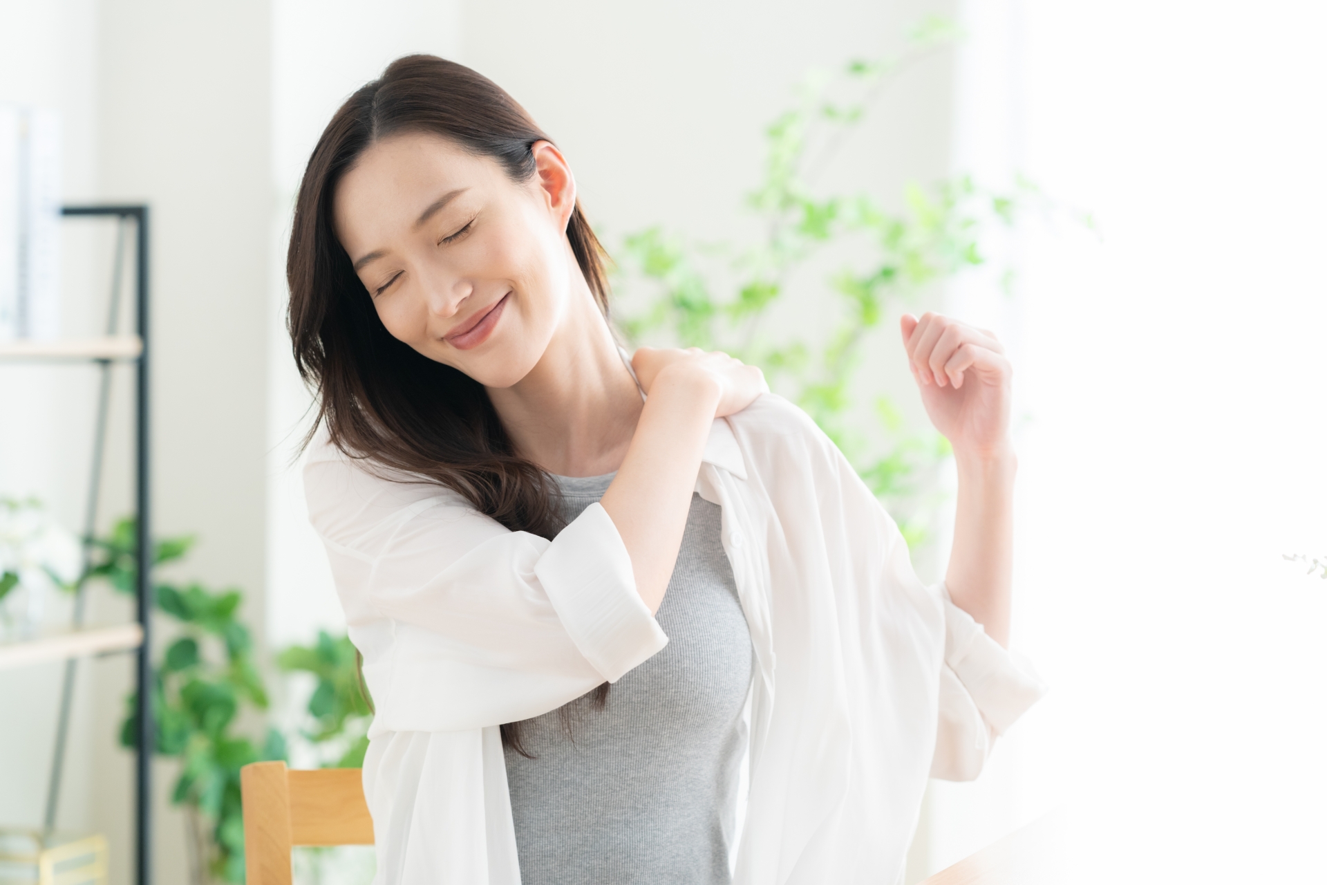 やさしい感覚入力を用いた施術を受けて肩の動きを整える女性のイメージ